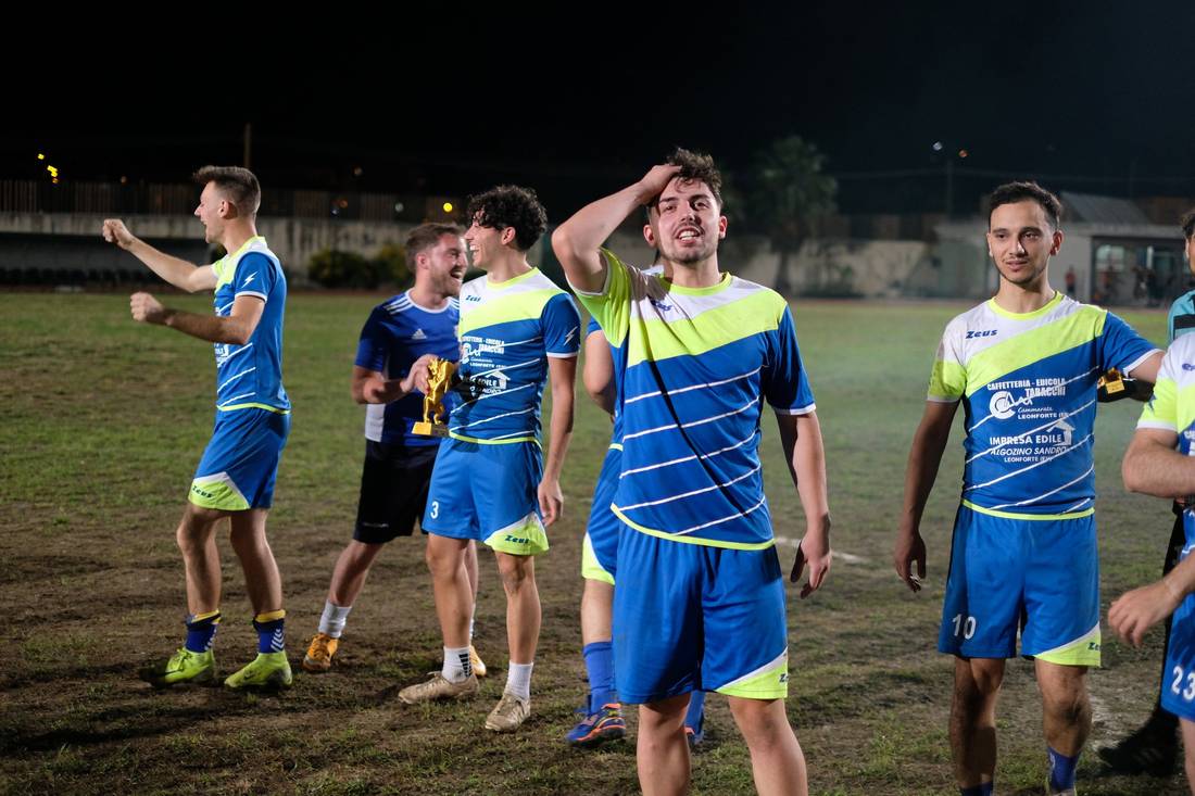 Giocatori in maglia blu festeggiano sul campo