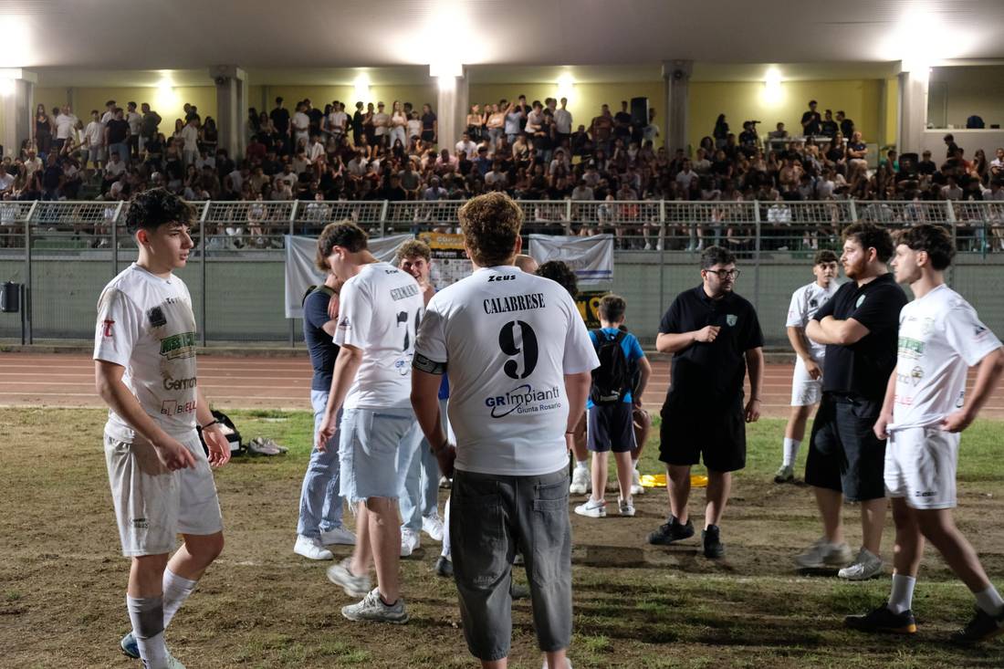 Giocatori in campo davanti agli spalti pieni